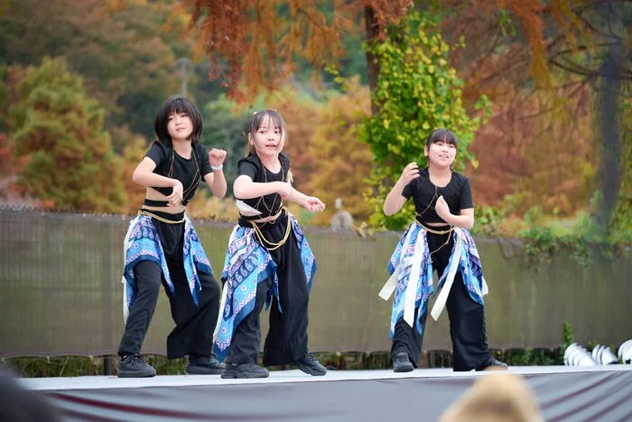 紅葉を背景にステージで踊る子どもたち